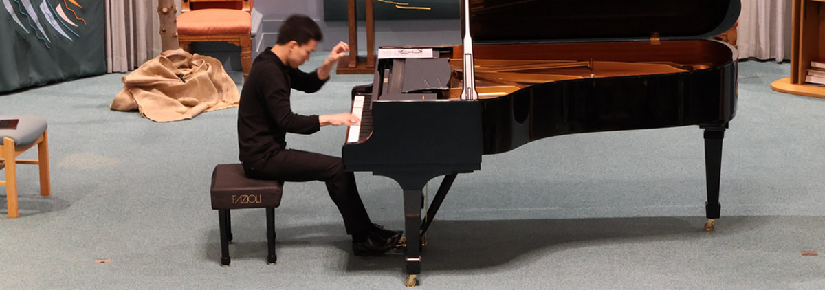 Victor Lim playing a grand piano